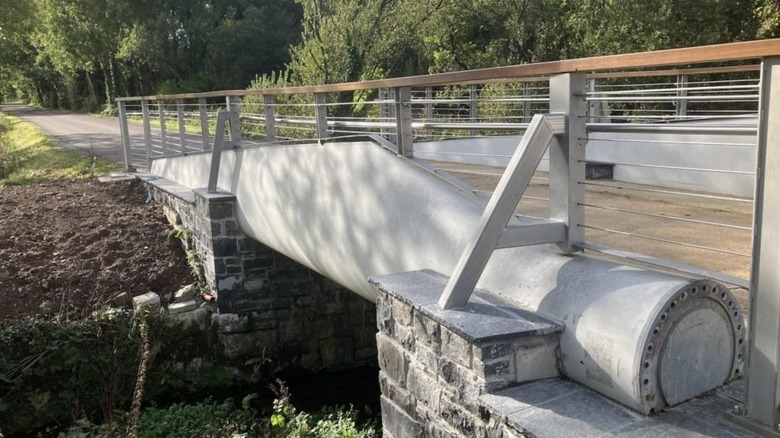 A bridge with a wind turbine blade used as a support.