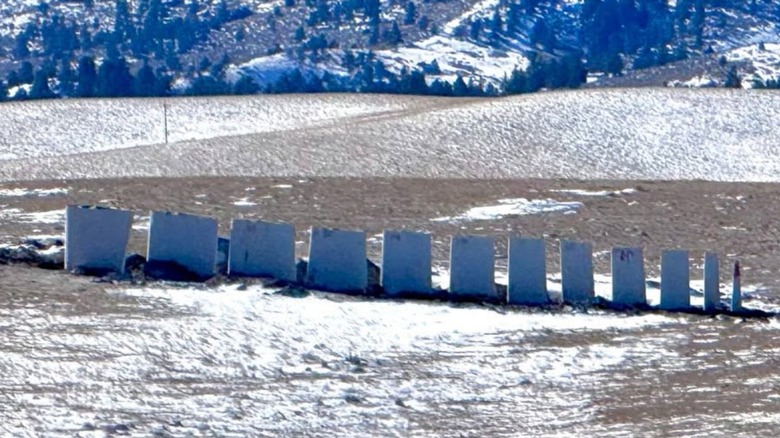 Several wind turbine blades set up in a field.