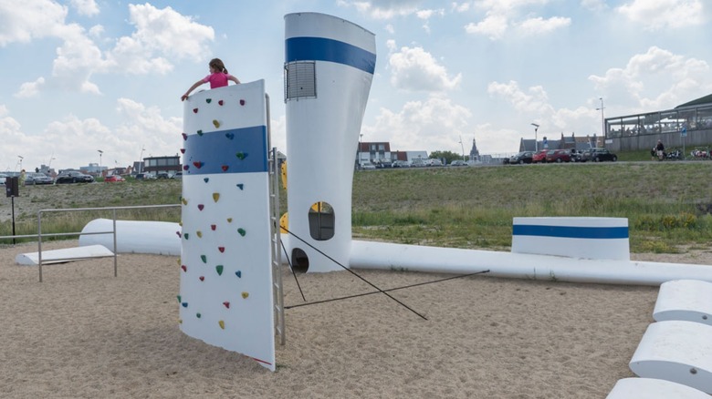Children playing on a wind turbine blade playground.