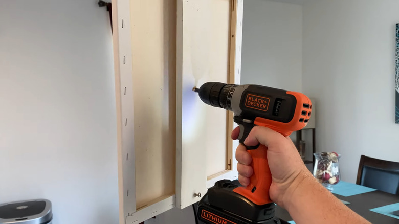 Using a cordless drill to paint on a canvas