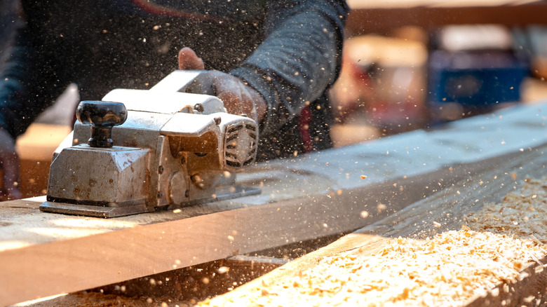 man using tool that creates tons of sawdust