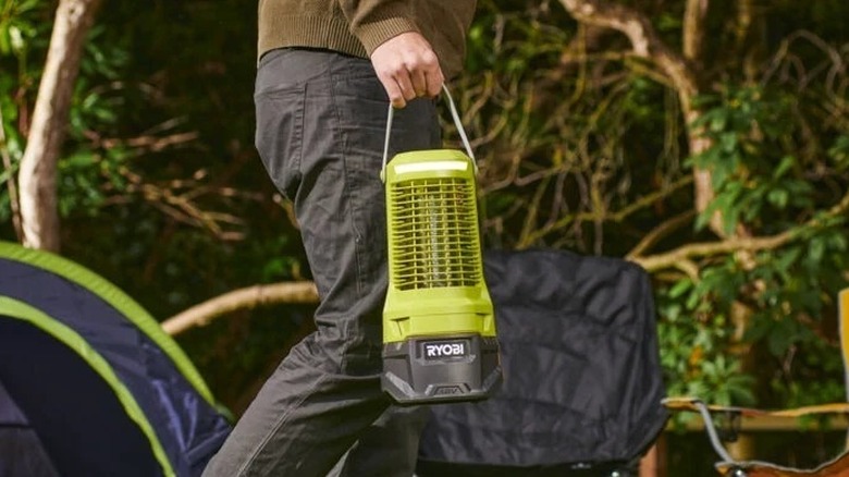 Man carrying Ryobi Bug Zapper in a camping ground