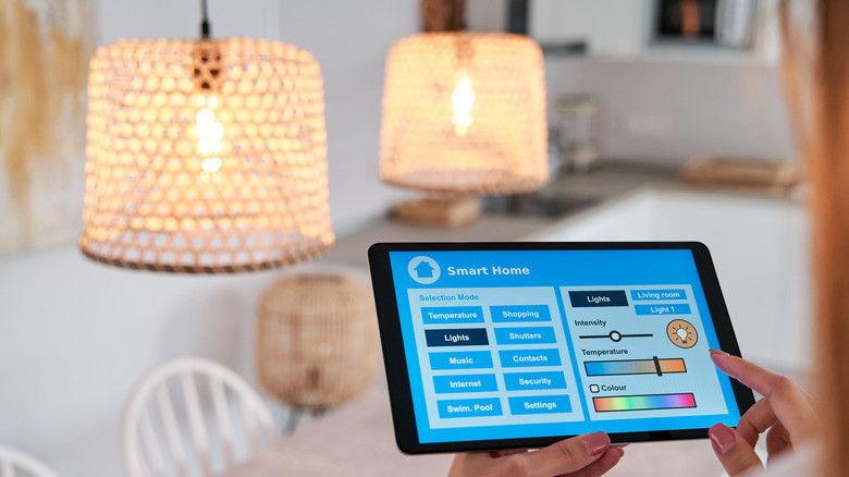 Person controlling smart bulbs in kitchen