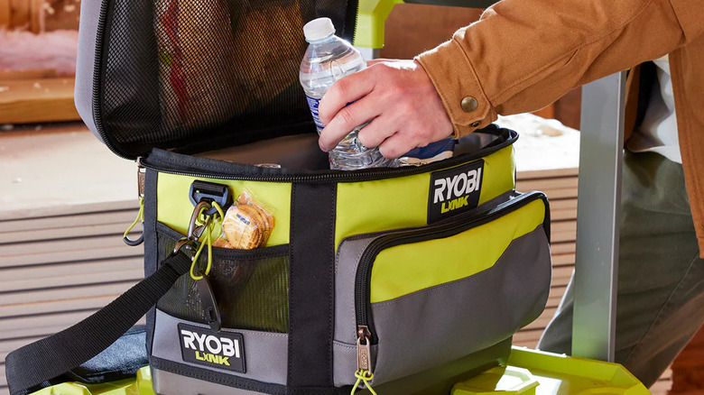 Closeup of person placing a plastic bottle in Ryobi's Soft Sided Cooler