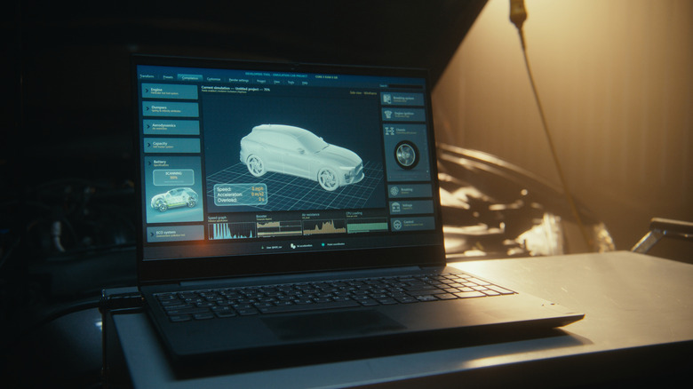 Laptop hooked up to car with ECU tuning software displayed on monitor