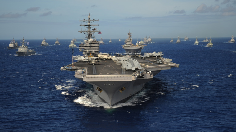 Aircraft carrier followed by fleet of ships