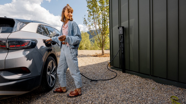 Person charging electric vehicle