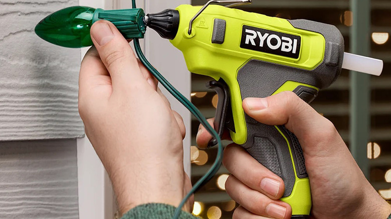 Man repairing some outdoor lighting with a Ryobi USB Lithium Glue Gun.