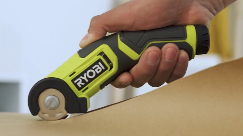 A close up of the Ryobi USB Lithium Power Cutter being used to cut material.