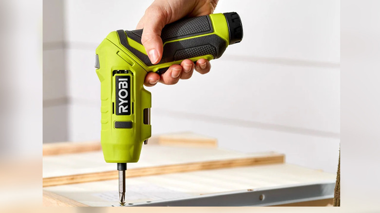 Ryobi USB Lithium screwdriver being used to tighten a screw in wooden furniture.