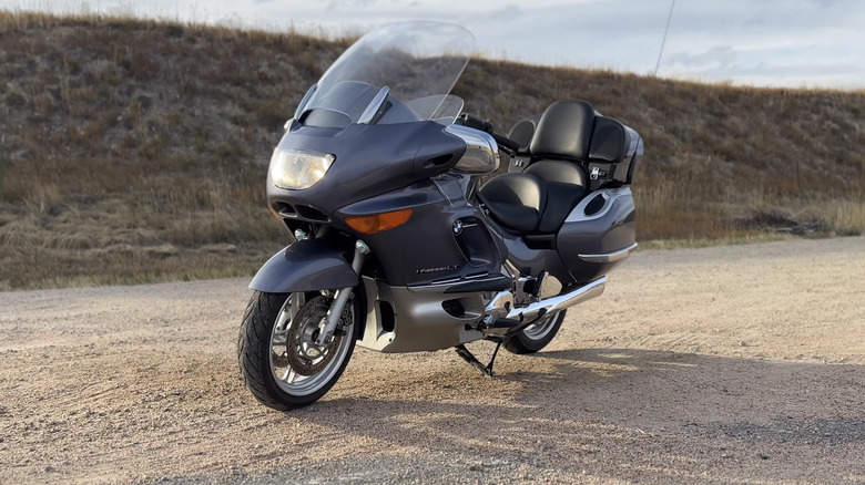 A silver BMW K1200 LT touring cruiser motorcycle parked on dirt, facing right to left.
