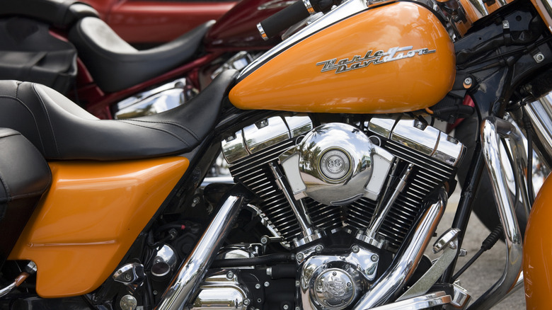 A mustard-yellow Harley-Davidson Road King equipped with the distinctive Twin Cam 88 engine parked indoors.