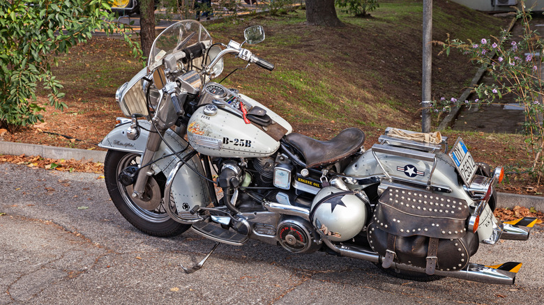 A white and silver customized Harley-Davidson FL-line Electra Glide motorbike parked at the side of a road.