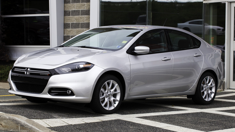 A silver 2013 Dodge Dart sedan parked outside.