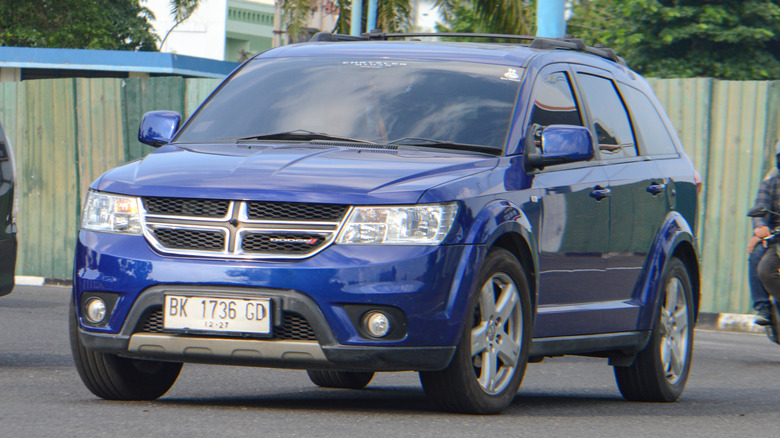 A blue Dodge Journey crossover being SUV driven on a road.