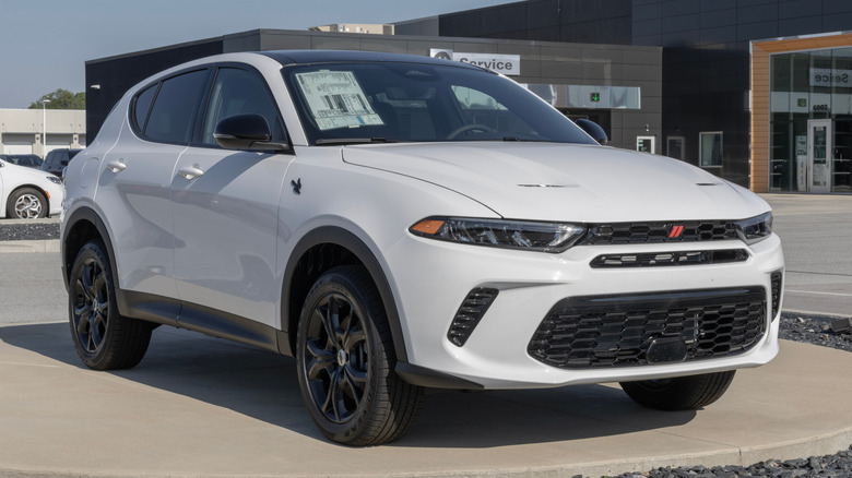 A white 2024 Dodge Hornet parked outside a dealership.
