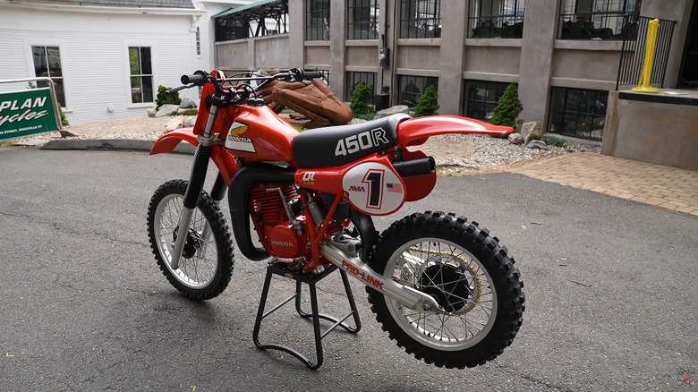 A red Honda CR450R from the 1981 debut model year on a specialized stand with all livery stickers intact.