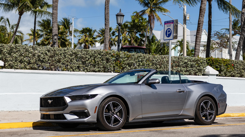 2024 Ford Mustang EcoBoost in gray on tropical city road, front 3/4 view, top down