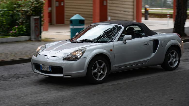 Toyota MR2 Spyder driving on italian road, front 3/4 view, silver exterior
