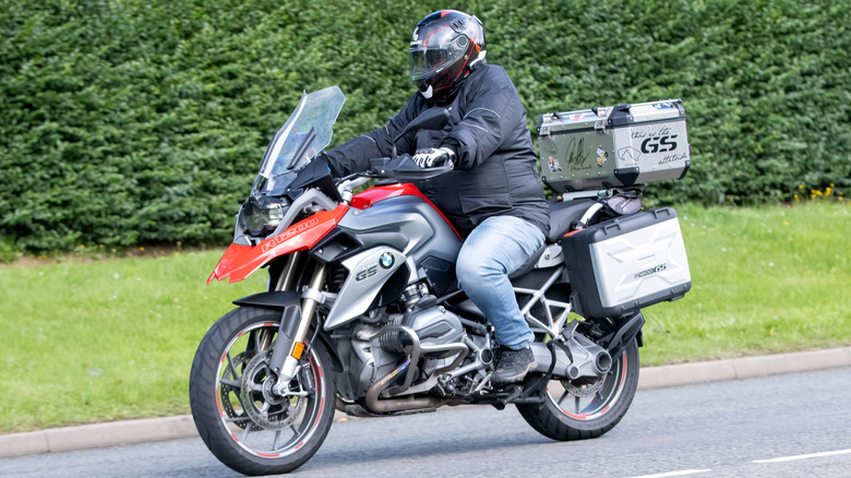 A person riding a BMW R1200 GS on a road.