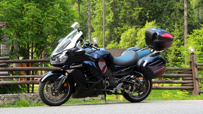 A Kawasaki 1400GTR on a road, trees in the background.