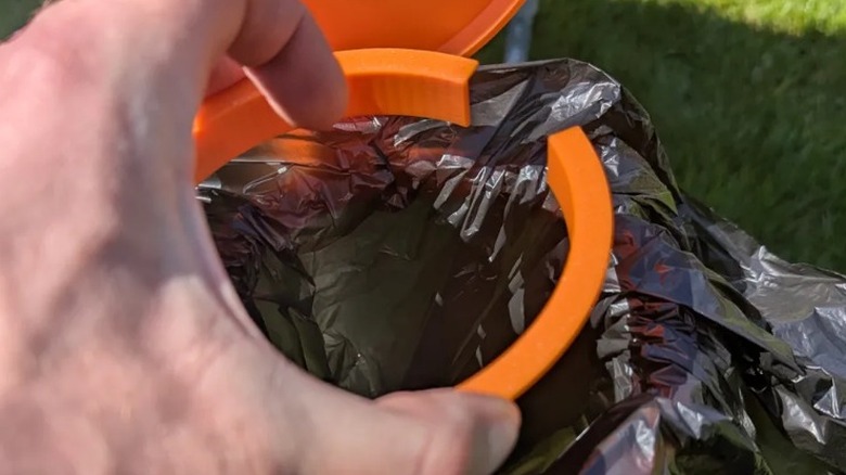Person installing camping waste bin