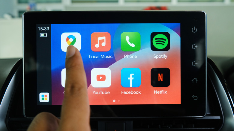 Person touching Maps app on Android Auto