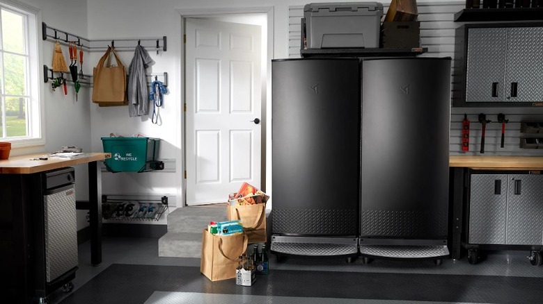 A trash compactor under a counter in a room.