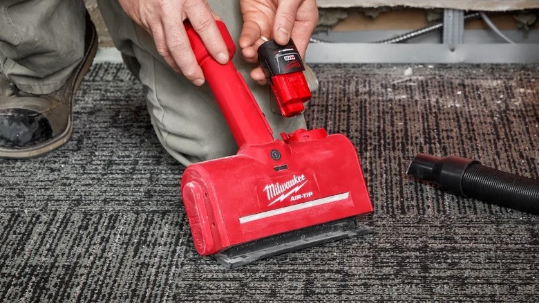 Person placing battery in Milwaukee M12 Air-Tip Powered Utility Nozzle