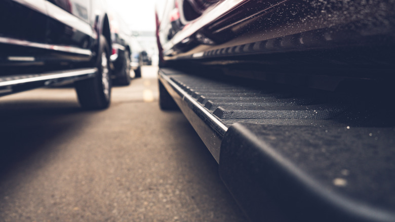 Close-up view of running boards on parked pickup trucks.