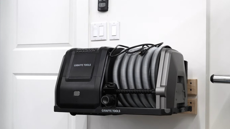 A wall-mounted Giraffe Tools-branded shop vac.