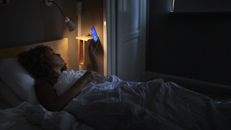 Woman using her phone in bed