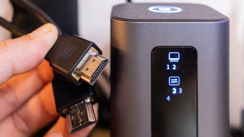 A DisplayLink dock with two external monitors connected to it next to two HDMI cables.