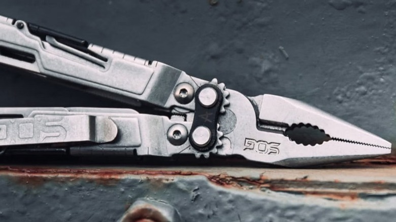 SOG PowerPint Mini Compact Stainless Steel Multi-Tool on rusted metal shelf