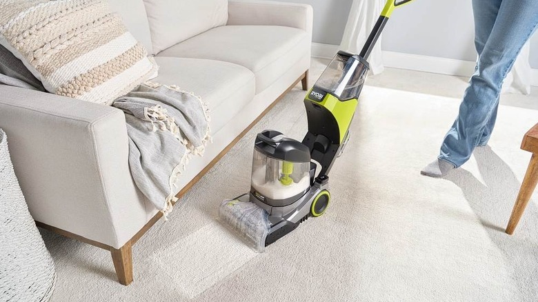 Woman using Ryobi carpet washer on carpet in living room