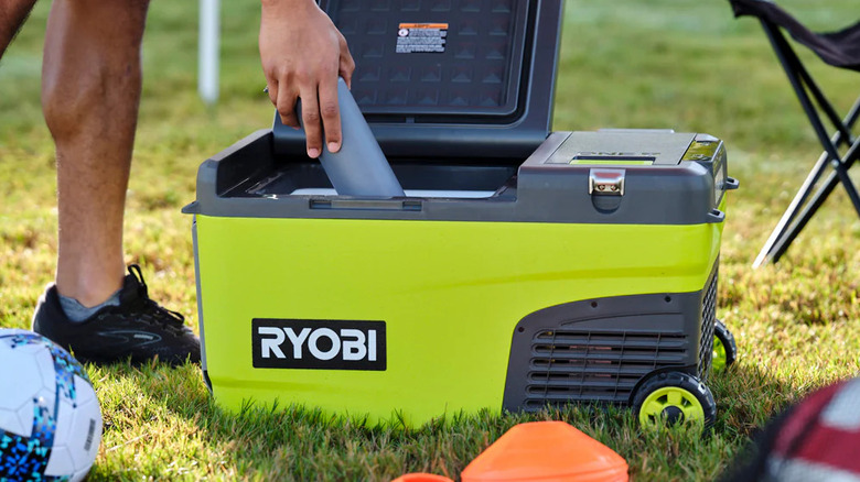 person getting drink from Ryobi cooler