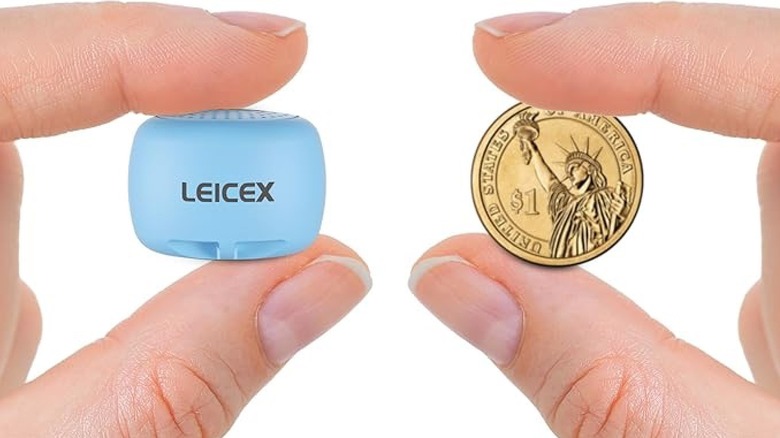 Tiny Bluetooth speaker held up to a coin for size comparison
