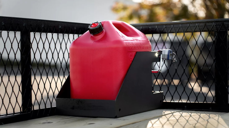 Red gas can being secured in a trailer by a locking rack