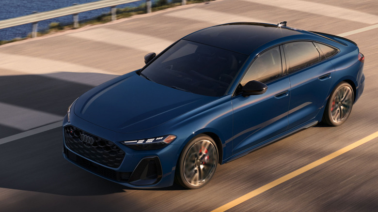 Overhead view of blue Audi S5 driving on coastal road.