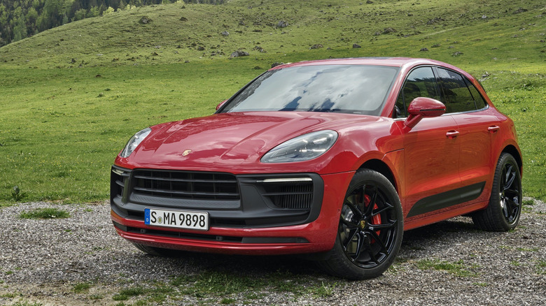 Front 3/4 view of red Porsche Macan GTS parked in mountains.