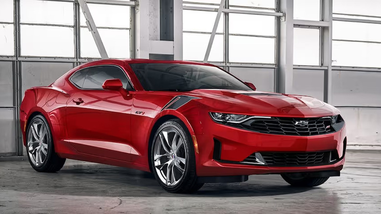 A red Chevrolet Camaro parked in a garage