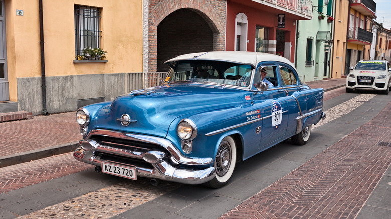 Blue classic Oldsmobile 88 parked on side of road