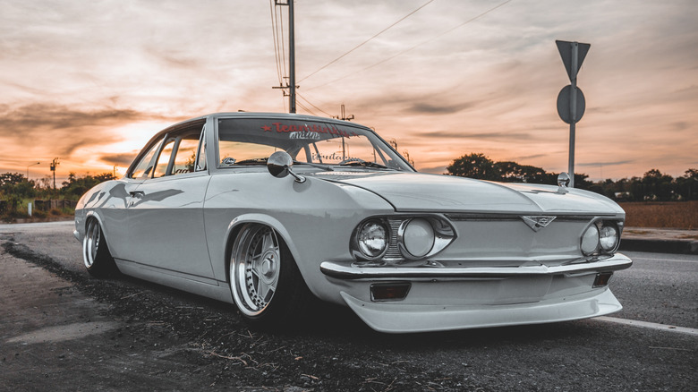 Front 3/4 view of white, customized and lowered Chevrolet Corvair.