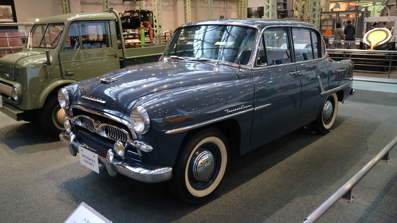 Front 3/4 view of classic Toyota Crown sedan on display inside of museum.