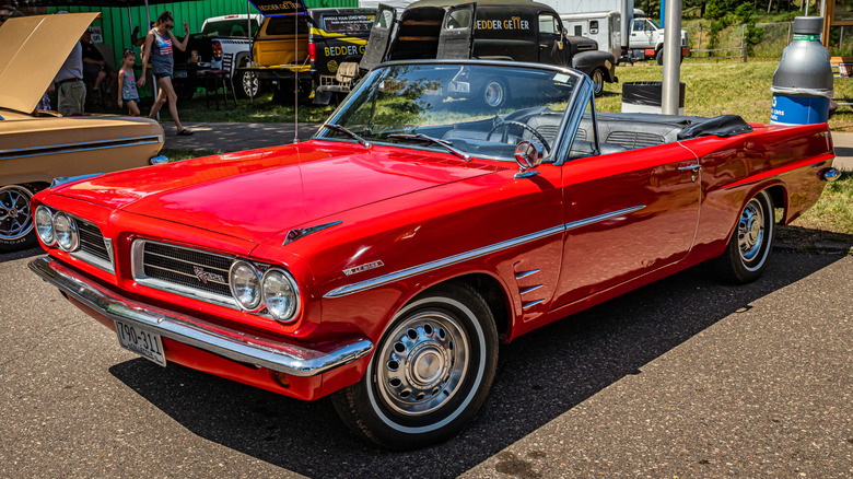Front 3/4 view of red 1963 Pontiac Tempest Le Mans convertible at car show.