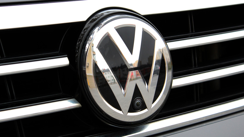 A closeup of the Volkswagen logo on a car's grille.