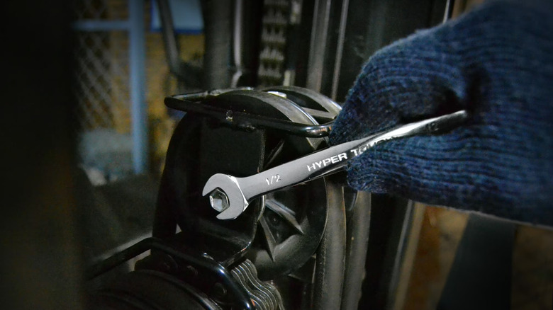 person using combination wrench