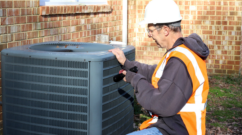 Man working on air conditioner outdoors