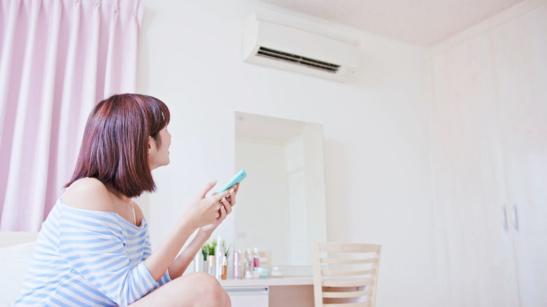 Woman looking at air conditioner