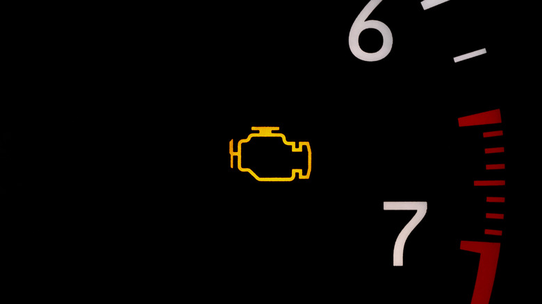 A check engine light in the middle of a vehicle tachometer
